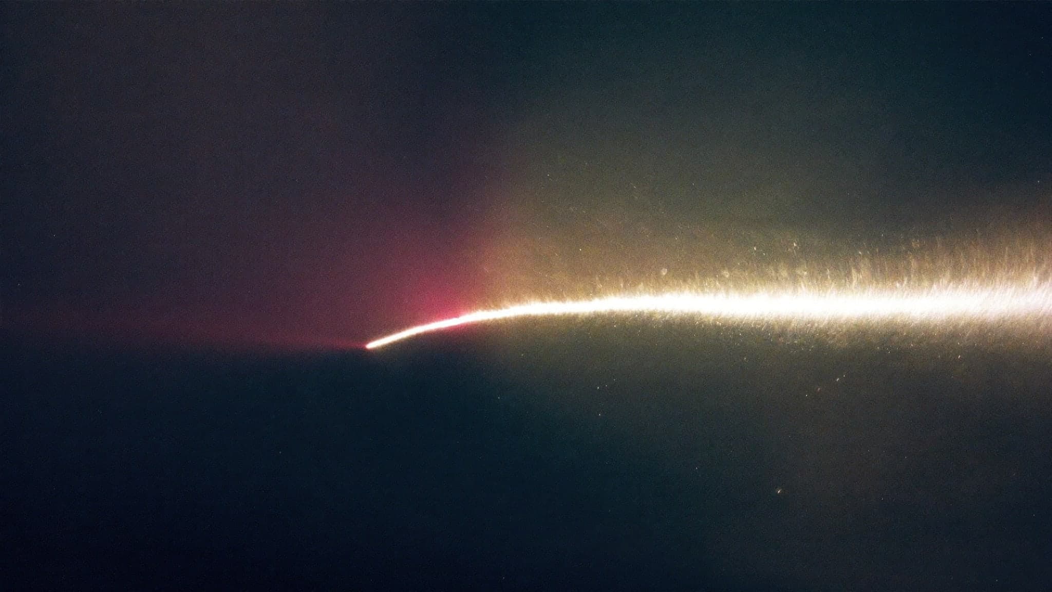 Una estela de luz cruzando la oscuridad en una exposición larga.